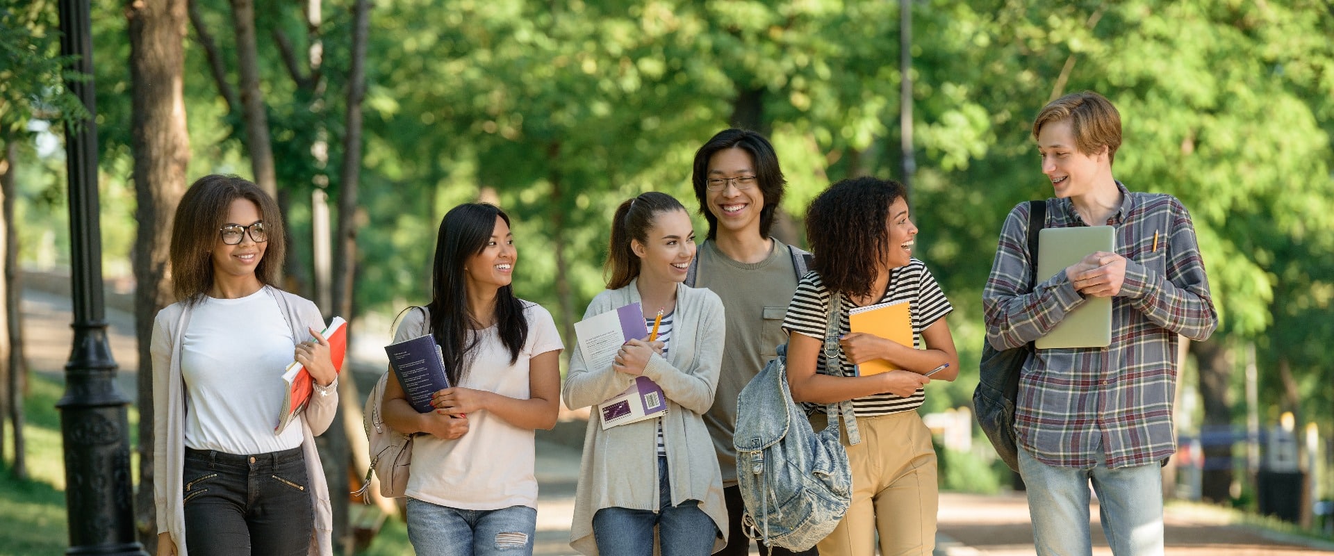 Happy young students walking outdoors